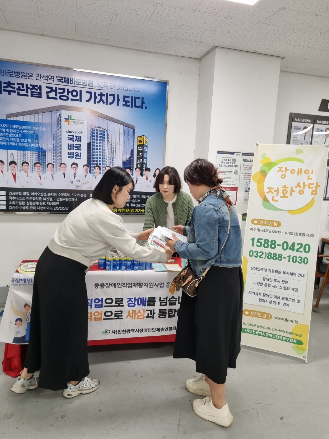 내방한 여성에게 장애인복지관련 리플렛과 홍보물품을 전달하는 모습
